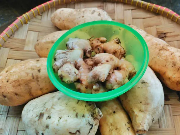 Endonezya yapımı tipik bir bambudan örülmüş yeşil bir kabın içindeki tatlı patates ve galangal.