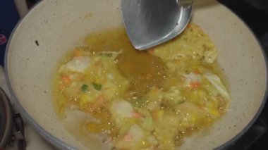 Bakwan Udang 'ı kızartma işlemi (karides bakwan). Karides bakwanı, buğday unlu hamur, karides ve havuç ve lahana gibi çeşitli sebzelerden yapılır.