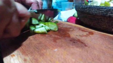 Lotek 'in yemek malzemelerinden biri olarak salatalık kesmek. Lotek, fıstık soslu (Endonezya) sebzelerden yapılan bir salatadır.