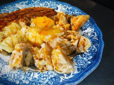 Bir tabak Baso Tahu (tofu köftesi), buğulanmış hamur köftesi, patates, tofu, lahana ve fıstık soslu ve soya soslu kavundan oluşan bir sokak yemeği.