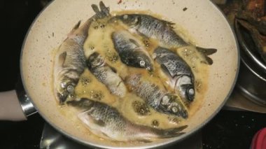 Kızartma tavası kullanarak birkaç akvaryum balığı kızartma işlemi.