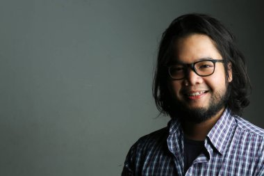 Closeup portrait of friendly smiling expressions of Asian men using low light photography techniques clipart