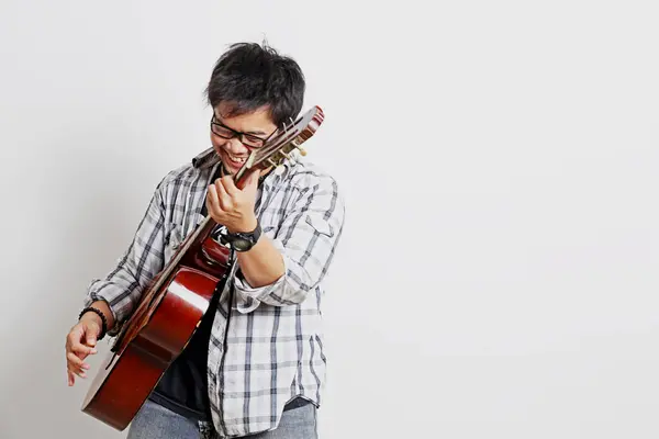 Akustik gitar çalan beyaz bir gitarist.