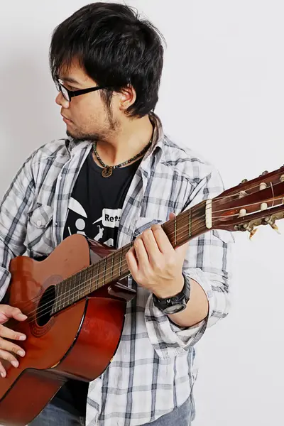 Akustik gitar çalan beyaz bir gitarist.