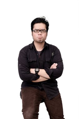 Kollarını kavuştururken somurtkan bir ifadeyle gözlük takan Asyalı bir adamın portresi, beyaz arka plan.