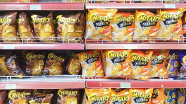 Bandung, Endonezya - 1 Ağustos 2024; süpermarket raflarında sıralanmış çeşitli Chitato marka patates cipsi atıştırmalıkları.