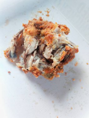 Beyaz arka planda kalan kızarmış tavuk göğsü, görünür kemikler ve hala bağlı kalan et.