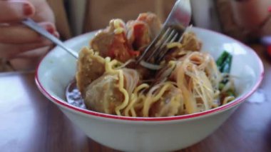 Baharatlı çorbalı bir kase köfteli şehriye iştah açıcı görünüyor. Erişte, vermicelli, pak choy sebzeleri, küçük köfteler ve büyük boy köftelerden oluşuyor.