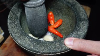 Kırmızı biber, sarımsak, tuz, şeker ve diğer malzemeler geleneksel taş havan ve sambal yapımında kullanılır. Popüler bir Endonezya biber sosu.