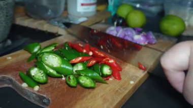 Yemek hazırlığı, kırmızı biber, kırmızı soğan ve yeşil biber parçaları kesim tahtasına.