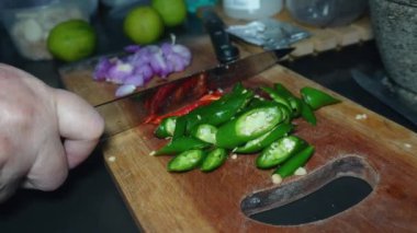 Yemek hazırlığı, kırmızı biber, kırmızı soğan ve yeşil biber parçaları kesim tahtasına.