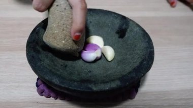 Geleneksel taş havan ve tokmak üzerinde öğütülmüş soğan ve sarımsak.