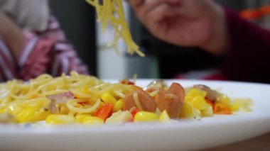 Bir çift birlikte aglio e olio spagetti yiyorlar evde füme sığır eti ve rendelenmiş mısırla tarifi yapıyorlar.