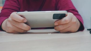 Akıllı telefon kullanan, akıllı telefonuyla oyun oynayan bir adama yaklaş.