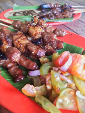 two kinds of goat satay dishes on the table, goat satay with peanut sauce and goat satay with tomato sambal clipart