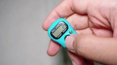 Elinde bir Müslüman, dhikr 'ı saymak için dijital tasbih tutuyor.