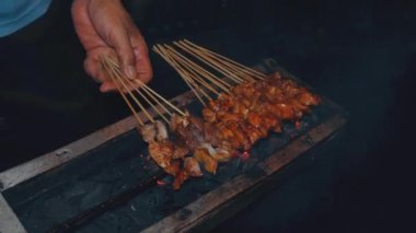 Sıcak kömürlerin üzerinde tavuk kızartma işlemi gece saten biri tarafından yellenirken...