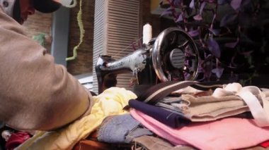 Eski bir dikiş makinesi olan mobil terzi servisi giysi, gömlek, pantolon, çanta ve yağmurluk onarım hizmeti veriyor.