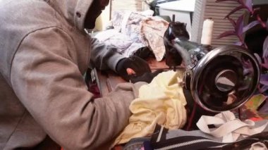 Bandung, Endonezya - 8 Aralık 2024; giysi, gömlek, pantolon, çanta ve hatta yağmurluk tamir etmek için eski bir dikiş makinesi olan mobil terzi