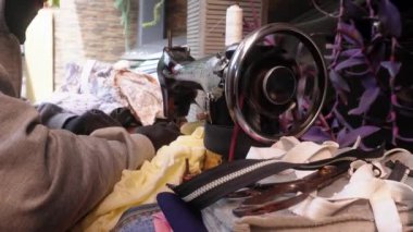 Bandung, Endonezya - 8 Aralık 2024; giysi, gömlek, pantolon, çanta ve hatta yağmurluk tamir etmek için eski bir dikiş makinesi olan mobil terzi