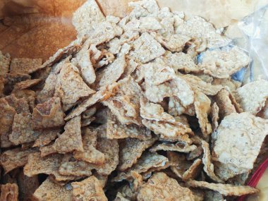 Close up texture of Keripik Tempe or Tempe chips, a typical Indonesian food made from thinly sliced tempeh and fried using seasoned flour. It's salty and savory clipart