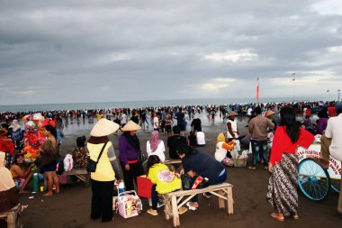 Bandung, Indonesia - January 5th 2014; Crowds of tourists at Pangandaran beach full with local and foreign visitor on holiday after new year clipart