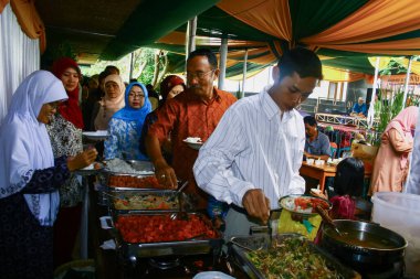 Sumedang, Endonezya - 13 Mart 2011; Davet edilen konuklar düğün etkinliğinde sırayla çeşitli büfe menüleri alıyorlar