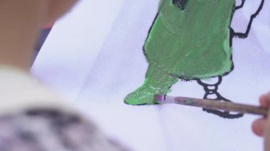 Suluboya ve fırça kullanarak küçük bir kızın elini boyamak, yaratıcılığı geliştirmek.