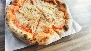 Tahta masada ev yapımı sekiz dilim peynirli pizza.