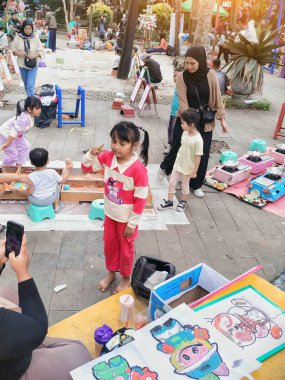 Bandung, Endonezya - 22 Aralık 2024; parkta tatil sabahları kalabalık, oyun, renk, gezi, aşçılık veya spor gibi pek çok aktivite yetişkinler ve çocuklar tarafından gerçekleştiriliyor.