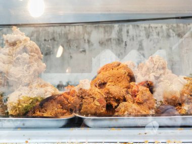 Fried chicken with a delicious crunch and authentic spices, sold in a glass display case clipart