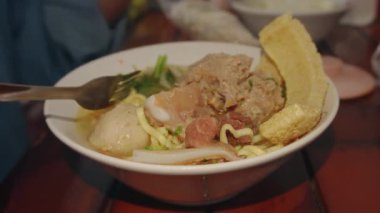 Lokantadaki kasede köfte çorbası (Bakso) içmek. Endonezya 'nın geleneksel sokak yemeklerinden biridir. Erişte çorbası ve köftelerden oluşur.