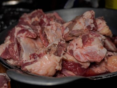 Çaydanlıkta bir yığın çiğ et var. Et çiğ ve çok yağlı. Mutfakta yemek hazırlığı.