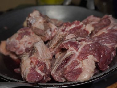 Çaydanlıkta bir yığın çiğ et var. Et çiğ ve çok yağlı. Mutfakta yemek hazırlığı.
