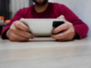 Akıllı telefon kullanan, ekranda kaydıran ve tıklayan bir adamın bulanık görüntüsü