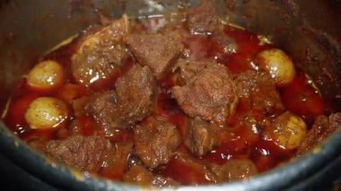 Batı Sumatra 'dan bir Endonezya yemeği olan Rendang' ı pişirme süreci. Çeşitli baharatlar ve hindistan cevizi sütü kullanılarak uzun ve düşük sıcaklıktaki pişirme sürecinden elde edilir.