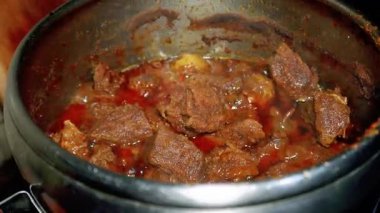 Batı Sumatra 'dan bir Endonezya yemeği olan Rendang' ı pişirme süreci. Çeşitli baharatlar ve hindistan cevizi sütü kullanılarak uzun ve düşük sıcaklıktaki pişirme sürecinden elde edilir.