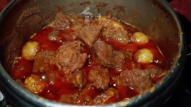 Batı Sumatra 'dan bir Endonezya yemeği olan Rendang' ı pişirme süreci. Çeşitli baharatlar ve hindistan cevizi sütü kullanılarak uzun ve düşük sıcaklıktaki pişirme sürecinden elde edilir.