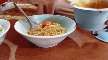 Mie Bakso yiyen bir kadın, ya da köfteli erişte çorbası, Endonezya 'nın en popüler mutfaklarından biri, sokak yemeklerinden, restoranlara kadar.