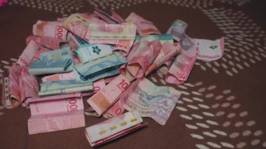 Bandung, Endonezya - 3 Nisan 2025; Endonezya Rupia 'sında el sayımı para, yüz elli bin banknot 