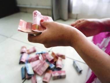 Bandung, Endonezya - 3 Nisan 2025; Endonezya Rupia 'sında el sayımı para, yüz elli bin banknot 