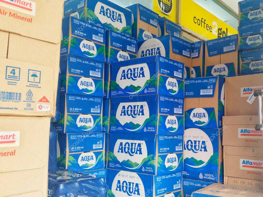 Bandung, Indonesia - April 20th 2025; Stacks of blue boxes of bottled mineral water of Aqua brand, with neatly arranged mountain designs