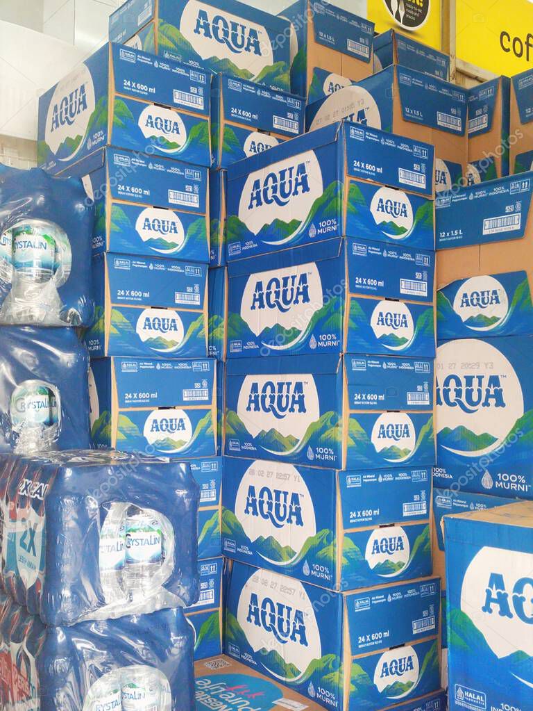 Bandung, Indonesia - April 20th 2025; Stacks of blue boxes of bottled mineral water of Aqua brand, with neatly arranged mountain designs
