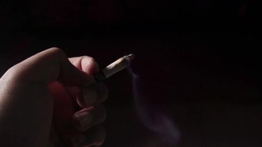 Siyah arka planda sigara içen adam elini kapat.