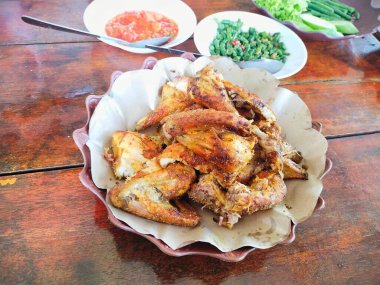 Bakakak Ayam (tipik Endonezya baharatları kullanılarak pişirilmiş ızgara tavuk) Sundan geleneksel restoranında taze sebze ve sambal ile servis edilir. Endonezya usulü ızgara tavuğun otantik tarifi