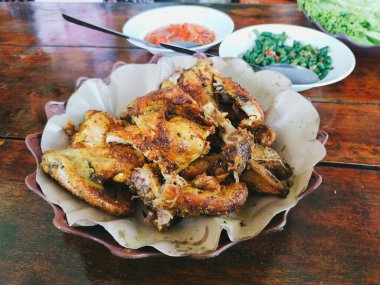 Bakakak Ayam (tipik Endonezya baharatları kullanılarak pişirilmiş ızgara tavuk) Sundan geleneksel restoranında taze sebze ve sambal ile servis edilir. Endonezya usulü ızgara tavuğun otantik tarifi