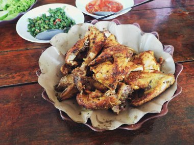 Bakakak Ayam (tipik Endonezya baharatları kullanılarak pişirilmiş ızgara tavuk) Sundan geleneksel restoranında taze sebze ve sambal ile servis edilir. Endonezya usulü ızgara tavuğun otantik tarifi