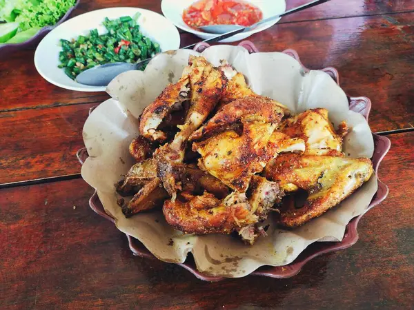 Bakakak Ayam (tipik Endonezya baharatları kullanılarak pişirilmiş ızgara tavuk) Sundan geleneksel restoranında taze sebze ve sambal ile servis edilir. Endonezya usulü ızgara tavuğun otantik tarifi