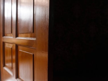 Yarı açık ahşap kapılı karanlık oda ve doğal ışık içeri giriyor.