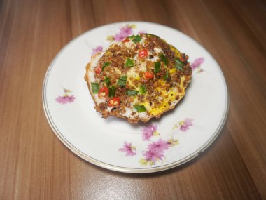 Indonesian street food, Serabi. It is traditional baked cake made from a mixture of rice flour and coconut milk. Topped with egg, chili, oncom (fermentation mixture of tofu dregs with Neurospora)